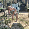 child, baby, swing, sleeping, outdoor, yard, fence, diaper, sunlight, shadow, grass, dirt, playground, resting, seat, summer, relaxed, toddler, empty_feet, nature