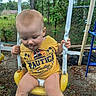 toddler, child, swing, playground, yellow, outdoor, trees, fence, grass, dirt, clothing, person, tongue_out, play, summer, legs, spots, casual, fun, nature
