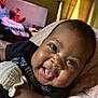 Summer is registered to the contest to win money with this photo: baby, black_clothing, blanket, cheek, closeup, couch, cute, expression, face, happy, head, human, indoor, infant, person, relaxed, skin, smiling, soft_texture, tongue_out
