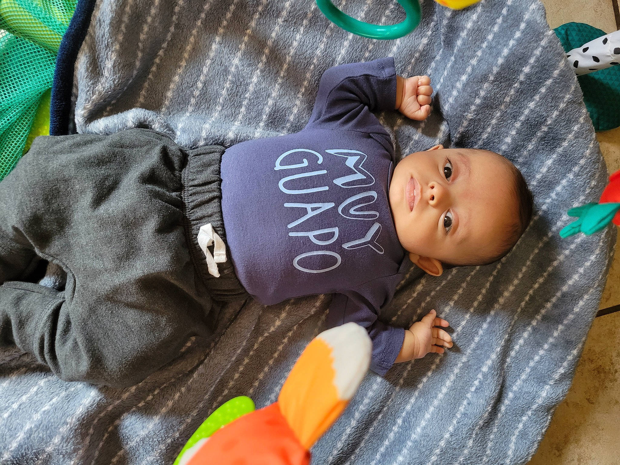 Aiden is registered to the contest to win money with this photo: baby, baby_products, baby_toddler_clothing, child, comfort, couch, flooring, green, hat, headgear, linens, nap, person, room, sitting, sleeve, smile, t_shirt, toddler, tree