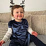 toddler, child, smiling, indoor, reindeer_headband, blue_dress, velvet, bow, leggings, couch, cozy, plush, happy, cute, festive, portrait, sitting, baby, person, home