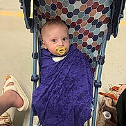 Eugene joined the competition — help win amazing prizes! baby, baby_clothing, blanket, child, colorful_pattern, cute, diaper_bag, floor, foot, footwear, hexagon_pattern, indoor, infant, pacifier, person, purple_cloth, seated, stroller, white_sandals, wrapped