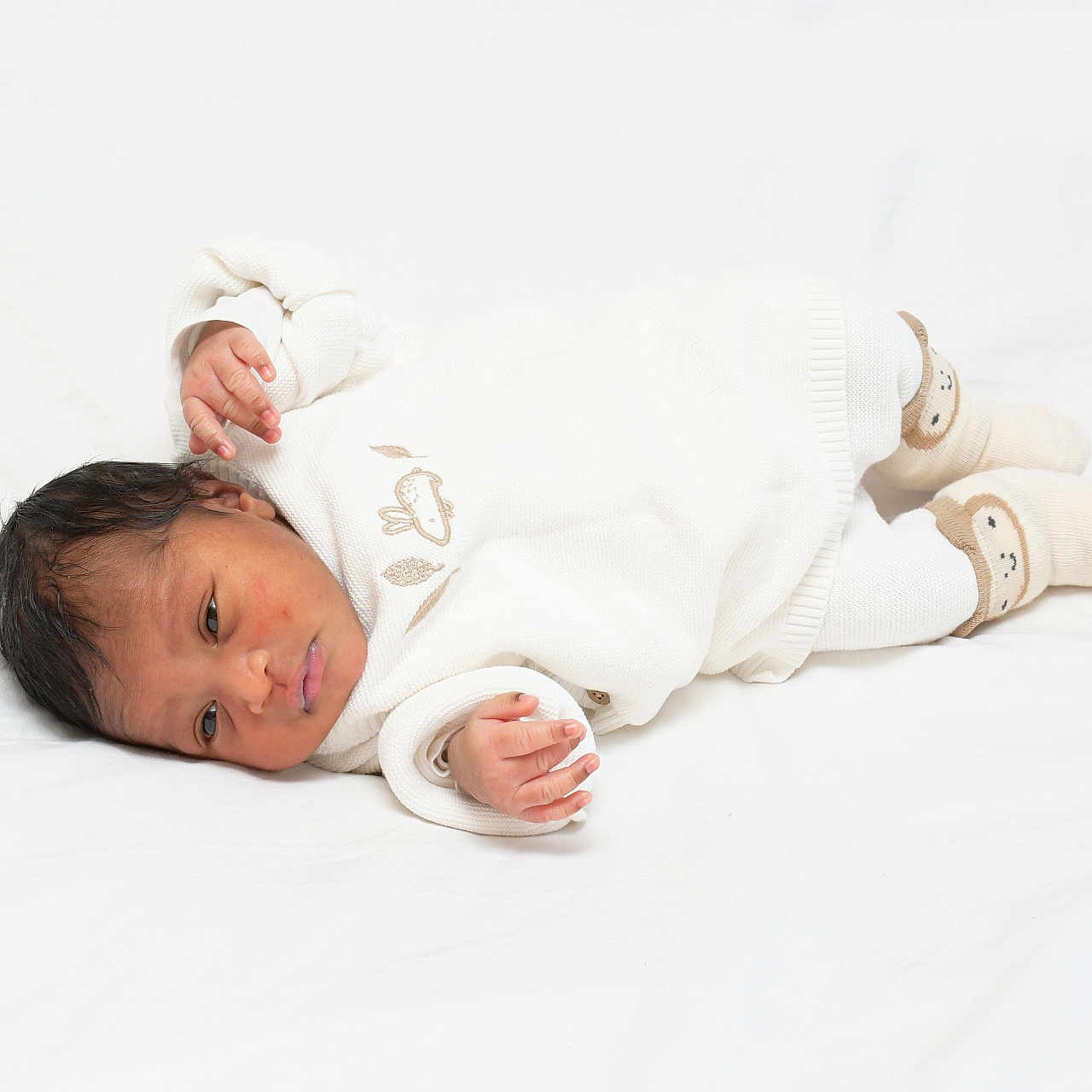 Lhayanna a rejoint le concours — aidez-le/la à gagner de superbes lots ! baby, child, cozy, curious, cute, face, footwear, hand, indoors, infant, lying_down, newborn, portrait, resting, skin, sleepwear, small, socks, soft_surface, white_clothing