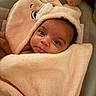 baby, child, hooded_towel, blanket, soft_texture, cute, face, wrapped, snug, indoor, newborn, infant, warm, cozy, towel, animal_ears, portrait, looking, curious, peaceful