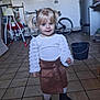 Ruby a rejoint le concours — aidez-le/la à gagner de superbes lots ! toddler, child, girl, blonde_hair, pigtails, white_top, brown_skirt, boots, indoor, tile_floor, bicycle, bucket, high_chair, utility_room, smiling, standing, person, clothing, portrait, floor