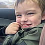 blurry_background, boy, car_interior, car_seat, casual_clothing, child, close_up, face, green_jacket, hair, happy, jacket, portrait, seatbelt, seatbelt_strap, skin, smile, travel, window, young_child