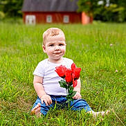 Waylon Kash joined the competition — help win amazing prizes! baby, child, toddler, portrait, outdoor, grass, garden, flowers, roses, bouquet, red_flowers, barn, countryside, greenery, sitting, smiling, blue_jeans, white_shirt, blond_hair, photography