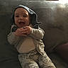 Skylo is registered to the contest to win money with this photo: baby, blanket, child, clothing, couch, cozy, cute, face, hand, happy, hoodie, indoor, infant, laughing, pants, person, portrait, sitting, smiling, young
