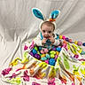 Skylo joined the competition — help win amazing prizes! baby, child, easter, bunny_ears, headband, colorful_eggs, blanket, patterned_blanket, curious, indoors, cute, infant, holiday, playful, soft_toys, festive, smiling, portrait, sitting, celebration