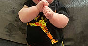 Skylo is registered to the contest to win money with this photo: apparel, baby, blanket, casual_wear, child, clothing, cute, expression, happy, indoors, infant, joyful, lying_down, person, portrait, shorts, skin, smiling, tshirt, young