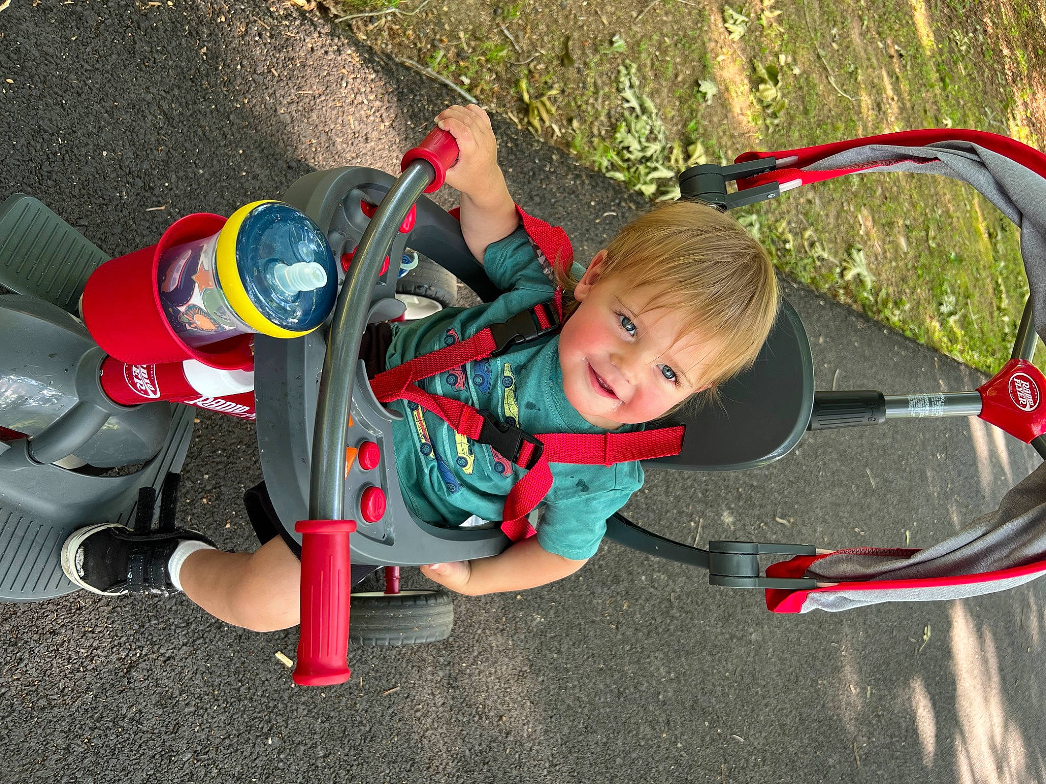 Hayes is registered to the contest to win money with this photo: adventure, asphalt, auto_part, automotive_exterior, automotive_tire, automotive_wheel_system, carmine, child, fun, joy, leisure, motor_vehicle, person, personal_protective_equipment, play, recreation, smile, steering_wheel, toddler, toy