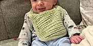 Jace joined the competition — help win amazing prizes! baby, bib, blanket, blue_pants, car_pattern, child, couch, cozy, cute, face, happy, home, indoor, infant, person, seated, smiling, soft_texture, white_socks, young_child