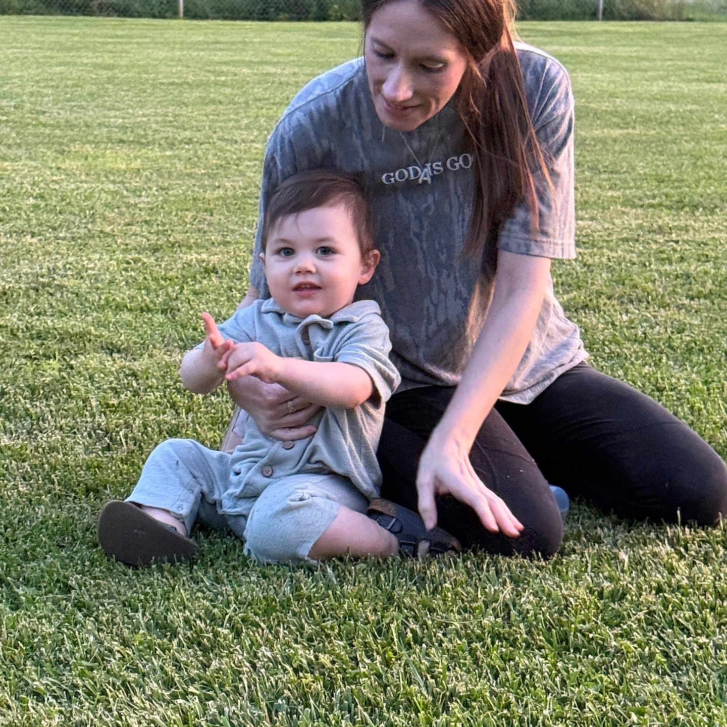 Haizen is registered to the contest to win money with this photo: care, casual_clothing, child, daylight, family, female, field, grass, greenery, happy, leisure, nature, outdoor, parent, people, portrait, sitting, smile, toddler, woman