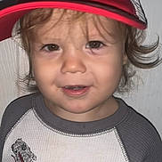 Ahser is registered to the contest to win money with this photo: advertisement, baby, baseballcap, cap, clothing, crying, face, frown, hat, head, logo, person, photography, portrait, poster, sad, shirt, sign, symbol, t_shirt