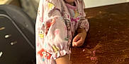 Molli is registered to the contest to win money with this photo: blurred_background, child, colorful, cute, face, furniture, hand, happy, home, indoors, pajamas, person, pink, playful, portrait, shower_cap, smiling, table, toy, wooden_table