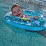 baby, child, pool, water, inflatable_ring, smiling, happy, tiled_floor, blue, swimming, floating, fun, summer, playful, cute, indoors, person, toddler, wet_hair, splash
