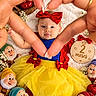 baby, infant, child, portrait, lying_down, snow_white, costume, red_bow, yellow_dress, blue_top, tulle_skirt, dwarfs, plush_toys, apples, flowers, heart_shape, hands, milestone_sign, fairytale, indoor