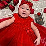 Ila Rose is registered to the contest to win money with this photo: baby, red_dress, headband, smiling, roses, newspaper, flower_petals, infant, happy, portrait, cute, child, lying_down, red_bow, celebration, tulle, face, skin, closeup, adorable