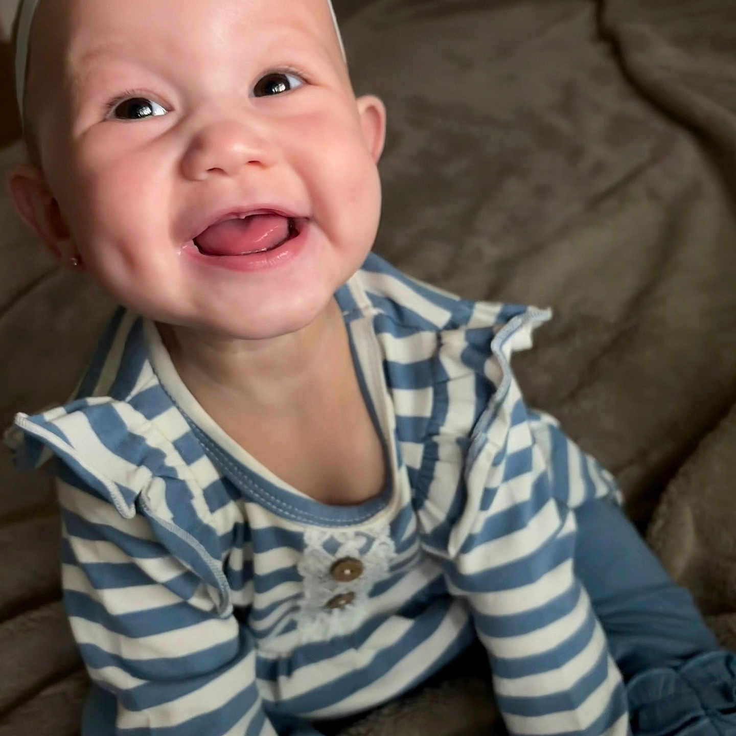 Ila Rose is registered to the contest to win money with this photo: baby, smiling, headband, bow, striped_clothing, blue, white, dimples, teeth, happy, sitting, blanket, soft, indoors, child, cute, portrait, young, person, infant