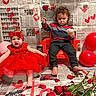 baby, toddler, child, red_dress, headband, cupcake, rose, balloon, newspaper, red_chair, rose_petals, handprints, hearts, floor, indoor, curly_hair, barefoot, painting, celebration, portrait