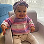 baby, child, smiling, headband, purple, sweater, striped, pastel_colors, armchair, indoor, curtain, window, light, happy, seated, barefoot, person, cute, infant, cozy
