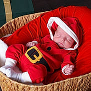 Thomas is registered to the contest to win money with this photo: baby, basket, child, christmas, cozy, cute, gift_box, headwear, holiday, indoors, infant, newborn, peaceful, plush_cushion, portrait, red_clothing, santa_outfit, sleeping, soft_lighting, white_socks