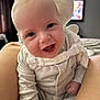 Rio is registered to the contest to win money with this photo: baby, blurred_background, casual, child, closeup, clothing, cozy, cute, eyes, face, happy, home, indoor, infant, legs, person, sitting, smiling, soft_lighting, television