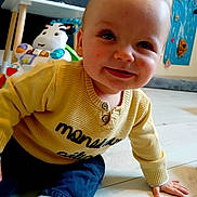 Lylio a rejoint le concours — aidez-le/la à gagner de superbes lots ! baby, blue_pants, child, crawling, cute, decor, face, floor, happy, indoor, person, playroom, smiling, sock, toy, wall_art, wooden_floor, yellow_sweater, young_child, zebra_toy