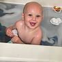 baby, child, bathtub, bath, water, toy, smile, happy, blue_eyes, skin, head, bald, hand, sitting, wet, indoor, play, floating, person, cute