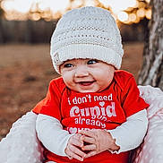 Opal joined the competition — help win amazing prizes! baby, infant, beanie, hat, red_shirt, smile, outdoor, tree, blanket, portrait, face, hands, cute, bokeh, warm_clothing, happy, sitting, park, grin, eyes
