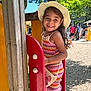 Lilya a rejoint le concours — aidez-le/la à gagner de superbes lots ! child, girl, smiling, hat, sunhat, playground, outdoor, daylight, colorful_clothing, summer, people, trees, wood, red, yellow, play_equipment, happy, portrait, casual, background