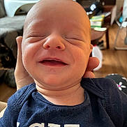 Colton joined the competition — help win amazing prizes! baby, cat, closeup, clothing, expression, face, furniture, hand, happy, head, holding, human, indoor, infant, newborn, person, portrait, shirt, skin, smiling