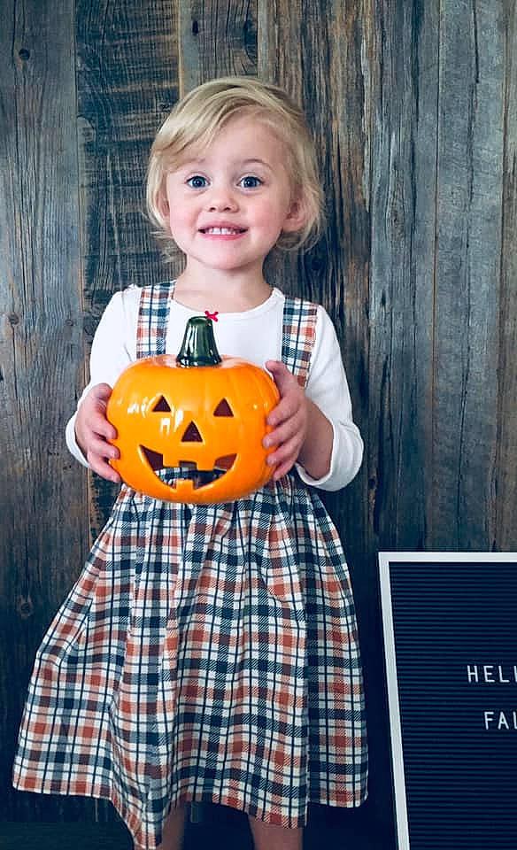 Sadie-mae is registered to the contest to win money with this photo: blond, calabaza, child, clothing, design, fruit, jack_o_lantern, joy, orange, pattern, person, plaid, plant, pumpkin, sleeve, smile, tartan, textile, toddler, trick_or_treat