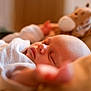 Freddie is registered to the contest to win money with this photo: baby, sleeping, blanket, soft_toy, giraffe, infant, closeup, cozy, warm_light, peaceful, child, indoors, portrait, cute, resting, newborn, comfort, tender, nursery, calm