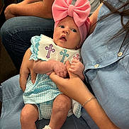 Berkley Rose joined the competition — help win amazing prizes! baby, infant, pink_bow, headband, blue_outfit, cross_embroidered, holding_hands, adult, jeans, seated, curious_expression, indoor, casual_clothing, white_shoes, close_up, portrait, person, family, cute, hands