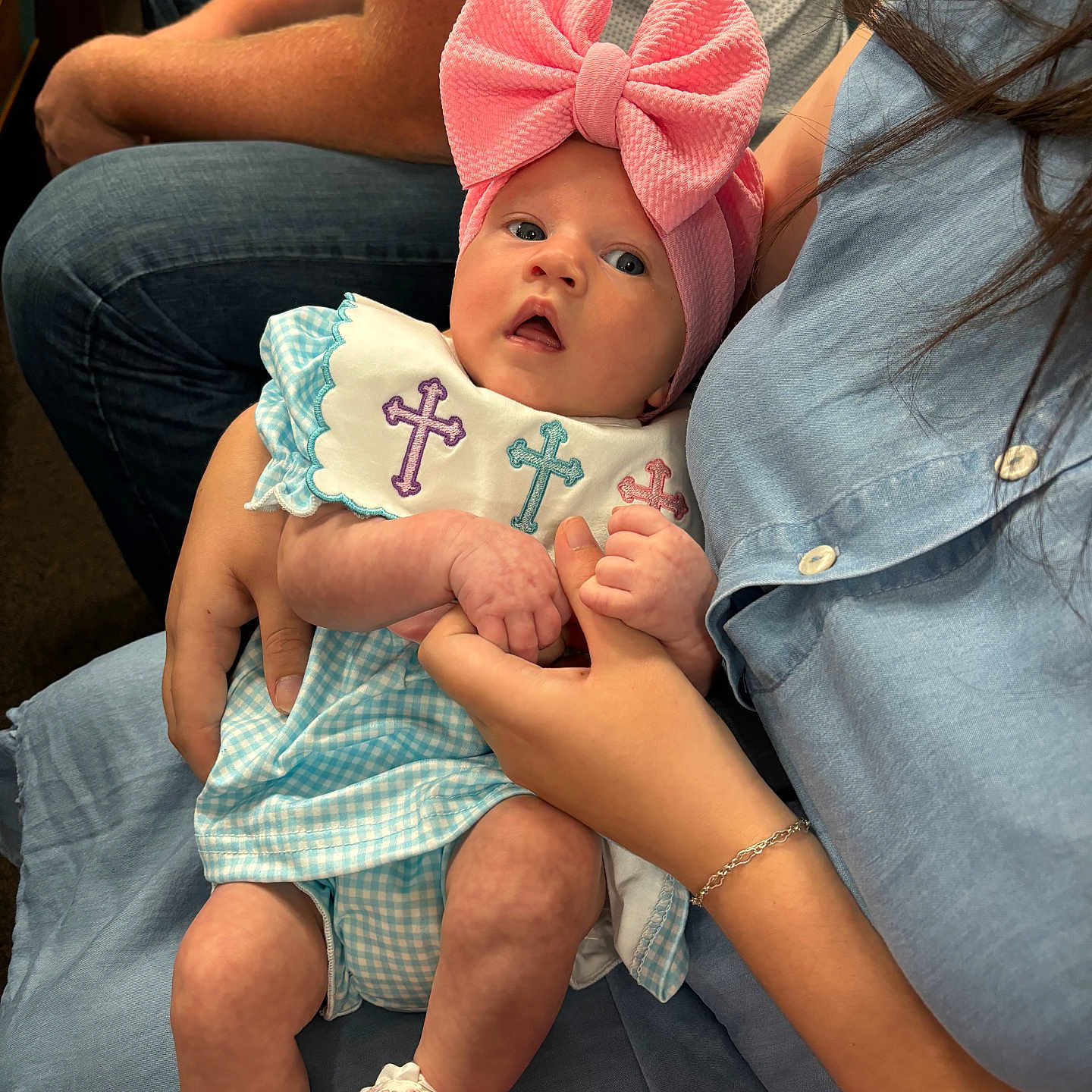 Berkley Rose joined the competition — help win amazing prizes! baby, infant, pink_bow, headband, blue_outfit, cross_embroidered, holding_hands, adult, jeans, seated, curious_expression, indoor, casual_clothing, white_shoes, close_up, portrait, person, family, cute, hands