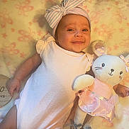 Aaliyah joined the competition — help win amazing prizes! baby, infant, smile, headband, plush_toy, bunny, pink, blanket, wooden_plaque, milestone, cute, lying_down, child, soft_toy, ribbon, celebration, portrait, two_months, happy, indoor