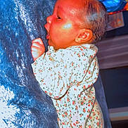 Amoura Lee is registered to the contest to win money with this photo: baby, infant, child, portrait, profile, sleeping, blanket, floral_outfit, clothing, cozy, indoor, colorful_lights, blue, close_up, face, ear, hair, baby_hand, cuddling, photography