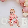 baby, child, pink_clothing, headband, balloons, birthday, number_one, white_floor, smiling, sitting, celebration, decorations, pastel_colors, cute, portrait, indoor, happy, one_year_old, festive, infant