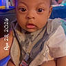 baby, child, infant, face, eyes, bib, clothing, socks, hand, indoor, person, portrait, cute, expression, skin, hair, seated, colorful, warm_lighting, holding