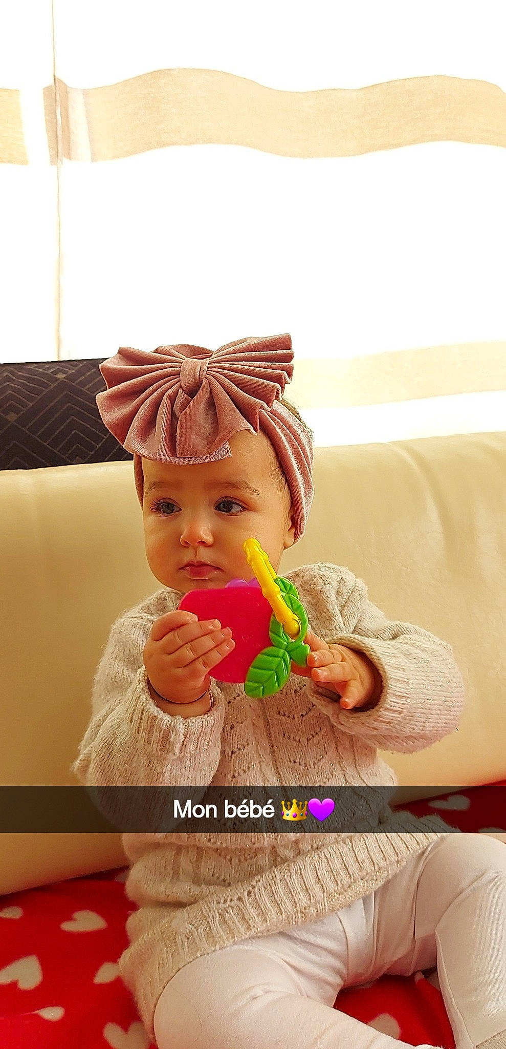 Gillya participe au concours pour gagner de l'argent avec cette photo : baby, baby_playing_with_toys, baby_toddler_clothing, cap, child, comfort, couch, doll, fashion_accessory, happy, headwear, human_body, magenta, nail, peach, person, sitting, skin, thumb, toddler