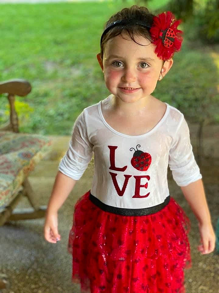 Ayva is registered to the contest to win money with this photo: baby, baby_toddler_clothing, child_model, day_dress, hair_accessory, happy, headband, headpiece, joy, mouth, outdoor_furniture, pattern, person, petal, red, summer, toddler