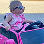 Kimber joined the competition — help win amazing prizes! child, baby, toddler, sunglasses, toy_car, pink_car, steering_wheel, pink_dress, pouting, earring, outdoor, gravel, blurred_background, parked_cars, side_mirror, toddler_seat, reflection_in_glasses, summer, playful, portrait