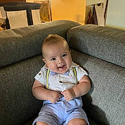 Brandon Marshall is registered to the contest to win money with this photo: baby, child, smile, couch, suspenders, bow_tie, shirt, shorts, indoor, furniture, happy, person, infant, seated, cute, face, home, light, room, portrait