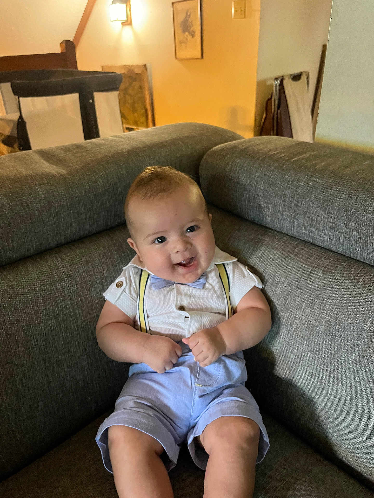 Brandon Marshall is registered to the contest to win money with this photo: baby, child, smile, couch, suspenders, bow_tie, shirt, shorts, indoor, furniture, happy, person, infant, seated, cute, face, home, light, room, portrait