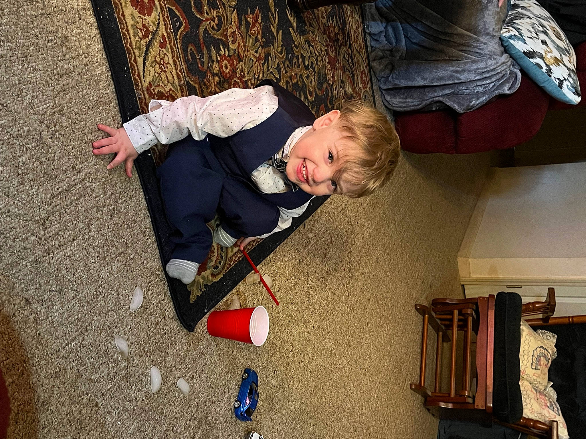 Parker is registered to the contest to win money with this photo: box, cardboard, child, flooring, fun, leisure, person, recreation, road_surface, room, shipping_box, shoe, sitting, sneakers, toddler, tree, wood