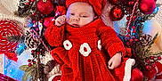 Livia participe au concours pour gagner de l'argent avec cette photo : baby, infant, red_dress, headband, bow, christmas_decorations, red_baubles, pine_cones, candy_cane, wrapped_presents, fairy_lights, blanket, festive, holiday, knitted_clothing, cozy, cute, indoors, celebration, sleepy