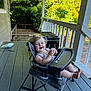 architecture, baby, backyard, building, chair, deck, face, furniture, head, house, housing, nature, outdoors, person, photography, porch, portrait, shelter, sitting, summer
