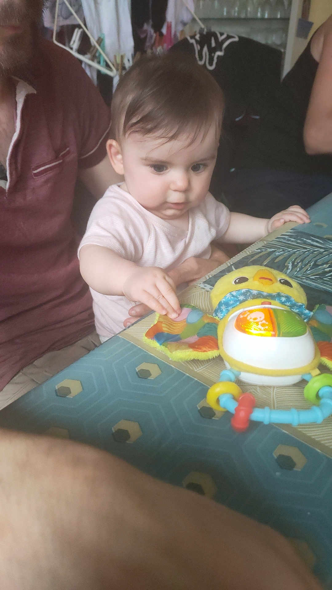 Ilyana a rejoint le concours — aidez-le/la à gagner de superbes lots ! baby, child, toy, table, adult, indoor, curious, colorful, person, hand, face, playing, clothing, pattern, furniture, light, focus, interaction, family, candid