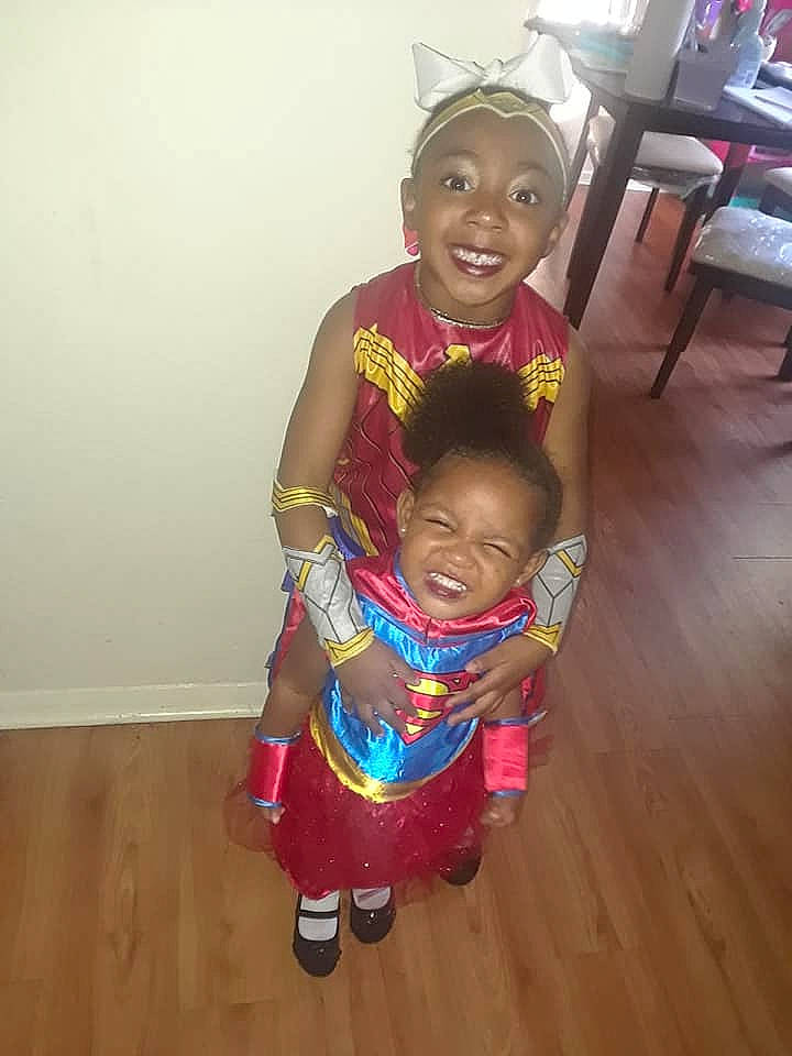 Imani is registered to the contest to win money with this photo: child, costume, day, fun, girl, happiness, headgear, joy, person, pink, play, product, skin, smile, standing, textile, toddler